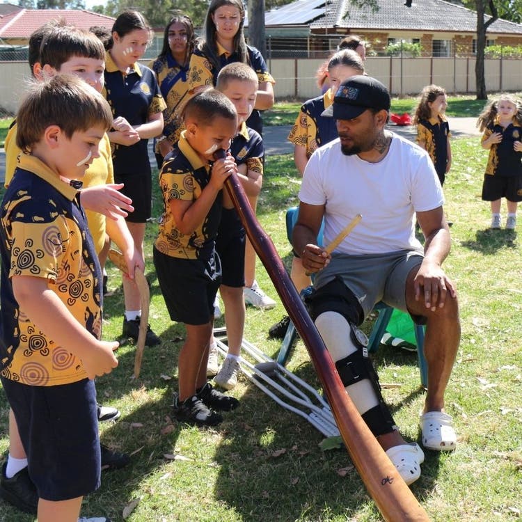 Celebrating NAIDOC week. Student playing didgeridoo.