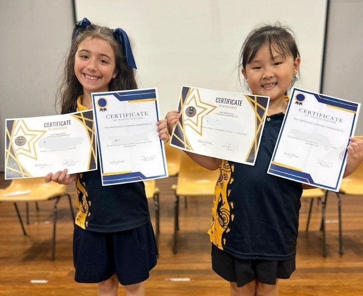 Two students with certificates for public speaking.